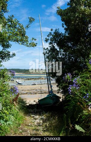 A sailing boat pulled up on a path leading down to Green Bay beach on Bryher, Isles of Scilly Stock Photo