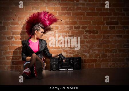 Young punk girl on brick wall background Stock Photo