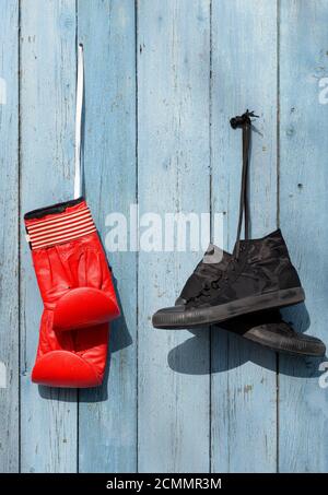 Black textile worn sneakers and red leather boxing gloves Stock Photo