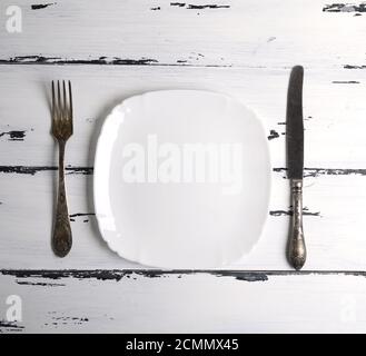 empty white ceramic plate with a fork and knife Stock Photo
