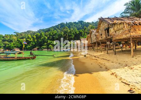 Traditional long-tail boats and houses of Moken tribe Village or Sea Gypsies and tropical waters of Surin Islands in Thailand, Phang Nga. Fisherman Stock Photo