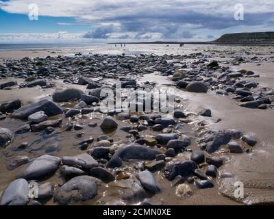 Stones and rocks on the beach at low tide at Port Eynon on the Gower penisula Wales UK Stock Photo