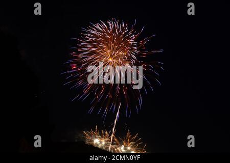 Red, orange, and blue fireworks display on the Fourth of July Stock Photo