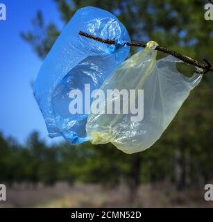 two used empty plastic bags hanging on a branch Stock Photo