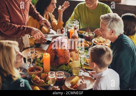 Cropped photo of family meeting served table thanks giving dinner two knives slicing stuffed turkey meal living room indoors Stock Photo