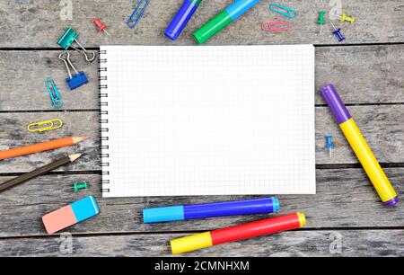 Close-up of empty notebook with many school objects on desk Stock Photo