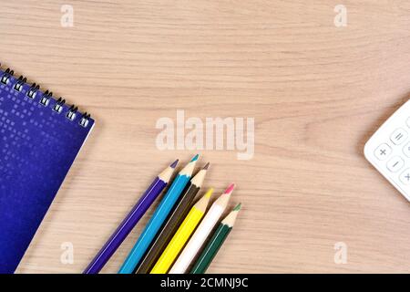 Colorful pencils with notebook and calculator on desk Stock Photo