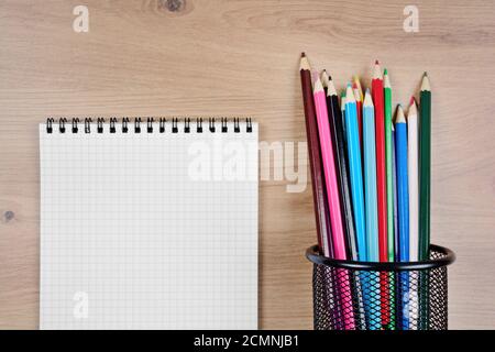Close-up of empty notebook with colorful pencils on table Stock Photo