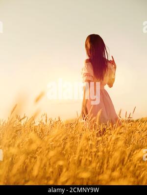 Woman in a wheat field at sunset Stock Photo - Alamy