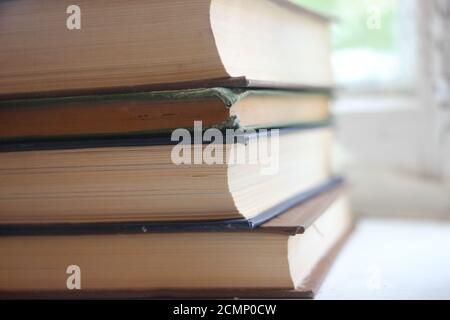 Stack of old hardcover books on a wooden surface. Knowledge education concept Stock Photo