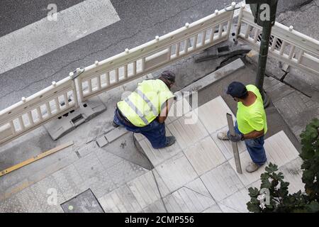 Construction workers repairing a sidewalk. Maintenance concept Stock Photo