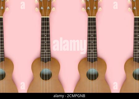 Small guitars on a pink pastel background. Musical equipment flat lay composition. Stock Photo