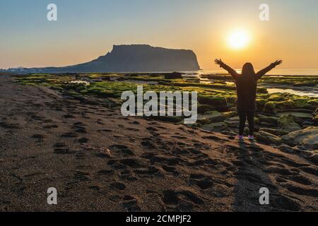 Jeju Island South Korea, Sunrise landscape at Seongsan Ilchulbong with woman tourist Stock Photo
