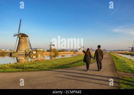 Rotterdam Netherlands, Love couple walking with Dutch Windmill at Kinderdijk Village Stock Photo