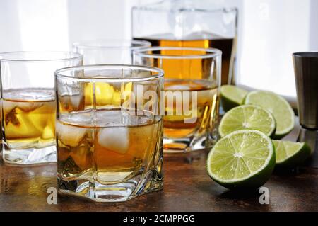 Alcohol cocktail with brandy, whiskey or rum with Ginger Ale, lime and ice in glasses Stock Photo