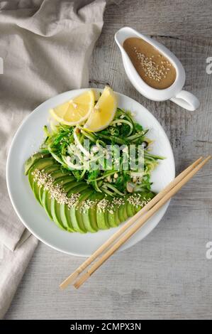 Chukka salad, cucumber noodles with avocado and peanut brown sauce in sauce boat Stock Photo