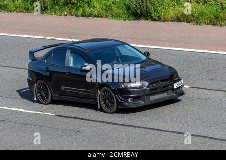 2008 black Mitsubishi Lancer 2.0 EVO X GSR SST FQ-330 4x4 4dr Vehicular traffic moving vehicles, modified cars driving vehicle on UK roads, motors, motoring on the M6 motorway highway network. Stock Photo