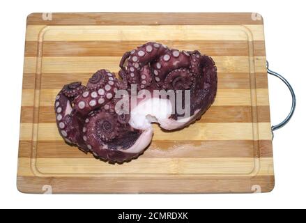 On the wooden kitchen cutting board lies a fresh red marine octopus Stock Photo