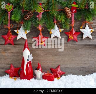 Christmas stars with gnomes and  branches of spruce on wooden background. Christmas or New Year greeting card. Stock Photo