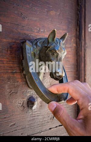 Guest Knocking Wooden Traditional Door, in front of the House Stock Photo