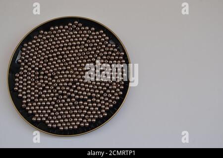 Plate, plate in black color with beads or round jewelry in silver, on white background with copy space, Brazil, South America Stock Photo