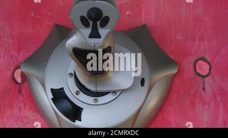 Joystick, silver game controller with controllers, with multiple buttons, used in computer or notebook video games, red wood background, Brazil, South Stock Photo