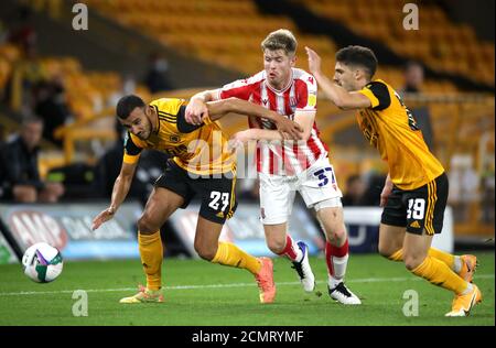 Stoke City's Nathan Collins (centre) battles for the ball with Wolverhampton Wanderers' Romain Saiss (left) and Ruben Vinagre during the Carabao Cup second round match at Molineux, Wolverhampton. Stock Photo