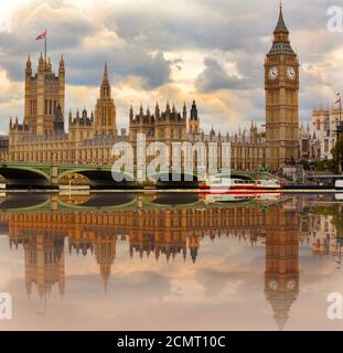 Big Ben and the Houses of Parliament on the River Thames with nice water reflection and cloudy sky.  London, UK Stock Photo