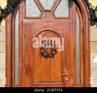 wooden door decorated with christmas wreath Stock Photo