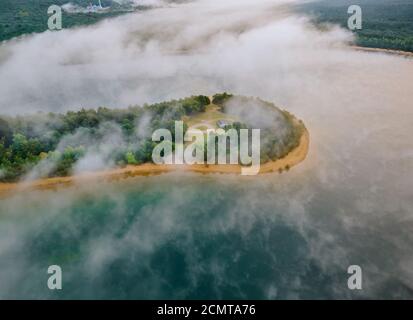 An aerial view of summary foggy morning in lakes over forest landscape