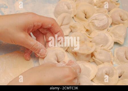 Modeling and cooking homemade dumplings woman chef at home Stock Photo