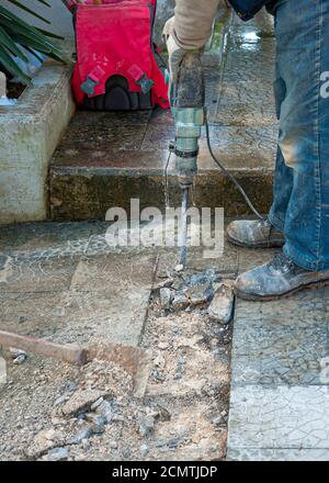 The construction worker is drilling the floor. Construction technicians ...