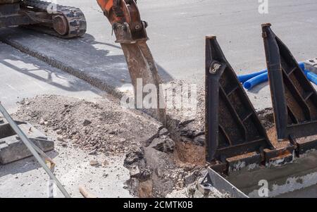 Worker movemen regulates the circulation of vehicles in an intersection affected by construction work on the fiber optic line Stock Photo