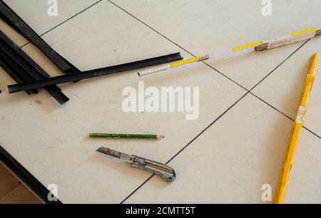 Raised Access Floor. In the process of being installed with work tools: spirit level, cutter, etc. Stock Photo