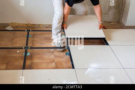 Worker install of raised floor in equipment room to spare space underground Stock Photo