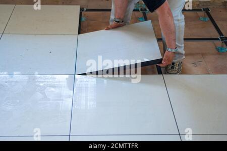 Worker install of raised floor in equipment room to spare space underground Stock Photo