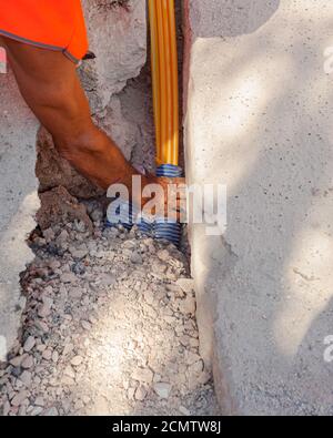 Worker inserts fiber optic cables buried in a micro trench Stock Photo ...