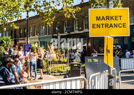 London, United Kingdom - September 13, 2020: Columbia Road Flower Sunday market. Market entrance and a quene of people waiting to get in Stock Photo