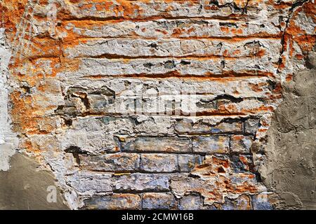 Grunge texture of old brick with plaster falls off in the background Stock Photo