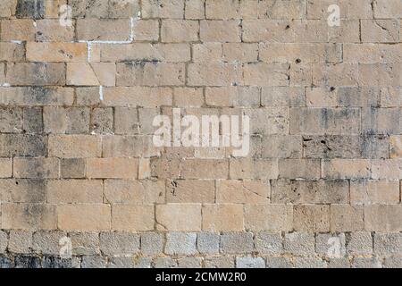 Exterior detail of an old Mediterranean historic building, stone wall facade and street. Stock Photo