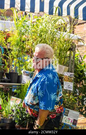 London, United Kingdom - September 13, 2020: Columbia Road Flower Sunday market. Market vendor in colourful shirt Stock Photo