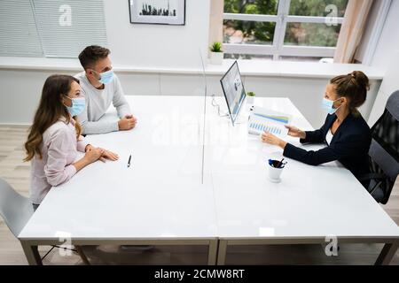 Young Family Couple Meeting Financial Advisor With Face Masks Stock Photo