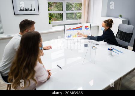 Young Family Couple Meeting Financial Advisor With Face Masks Stock Photo