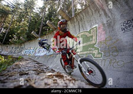 Downhill bikers Kemal Mulic (R) and Kamer Kolar train on the disused bobsled track from the 1984 Sarajevo Winter Olympics on Trebevic mountain near Sarajevo, Bosnia and Herzegovina, August 8, 2015. Abandoned and left to crumble into oblivion, most of the 1984 Winter Olympic venues in Bosnia's capital Sarajevo have been reduced to rubble by neglect as much as the 1990s conflict that tore apart the former Yugoslavia. The bobsled and luge track at Mount Trebevic, the Mount Igman ski jumping course and accompanying infrastructure are now decomposing into obscurity. The bobsled and luge track, whic