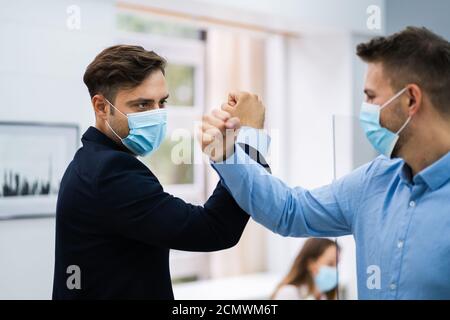 Employees Doing Elbow Bump To Avoid Flu And Stop Covid Spread Stock Photo