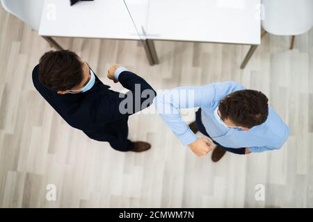 Employees Doing Elbow Bump To Avoid Flu And Stop Covid Spread Stock Photo