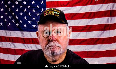 Vietnam Veteran With Far Away Look With American Flag Background Stock Photo