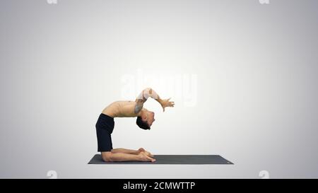 Yogi doing camel yoga pose on gradient background. Stock Photo