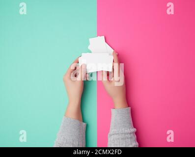 two female hands holding a stack of empty white paper business cards Stock Photo