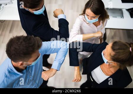 Employees Doing Elbow Bump To Avoid Flu And Stop Covid Spread Stock Photo